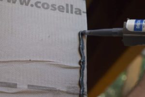 Applying DELTA®-TILAXX adhesive sealant around the very edges of the opening