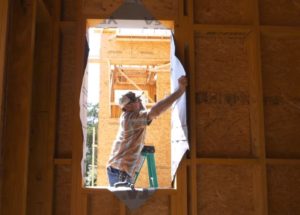 man folding the flaps of the housewrap